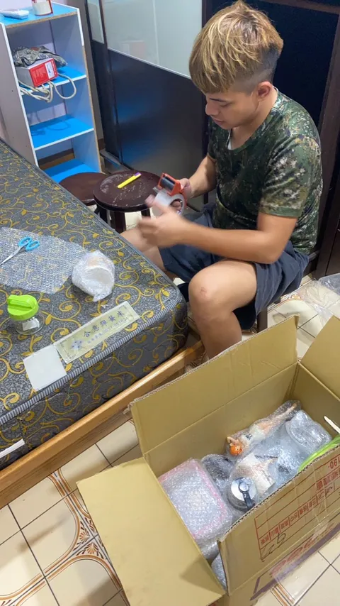 師傅坐在床邊把小物件包好放進紙箱
